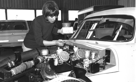 A worker retouching the paintwork under the hood